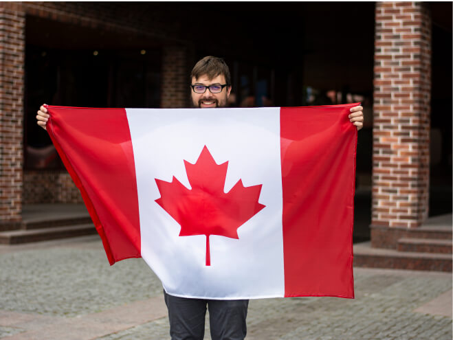 Une photo d'un homme en lunettes tenant le drapeau canadien